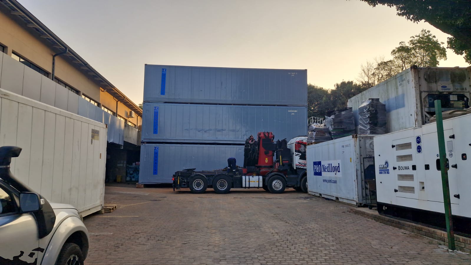AquaCat depot yard with crane truck and stacked reefers